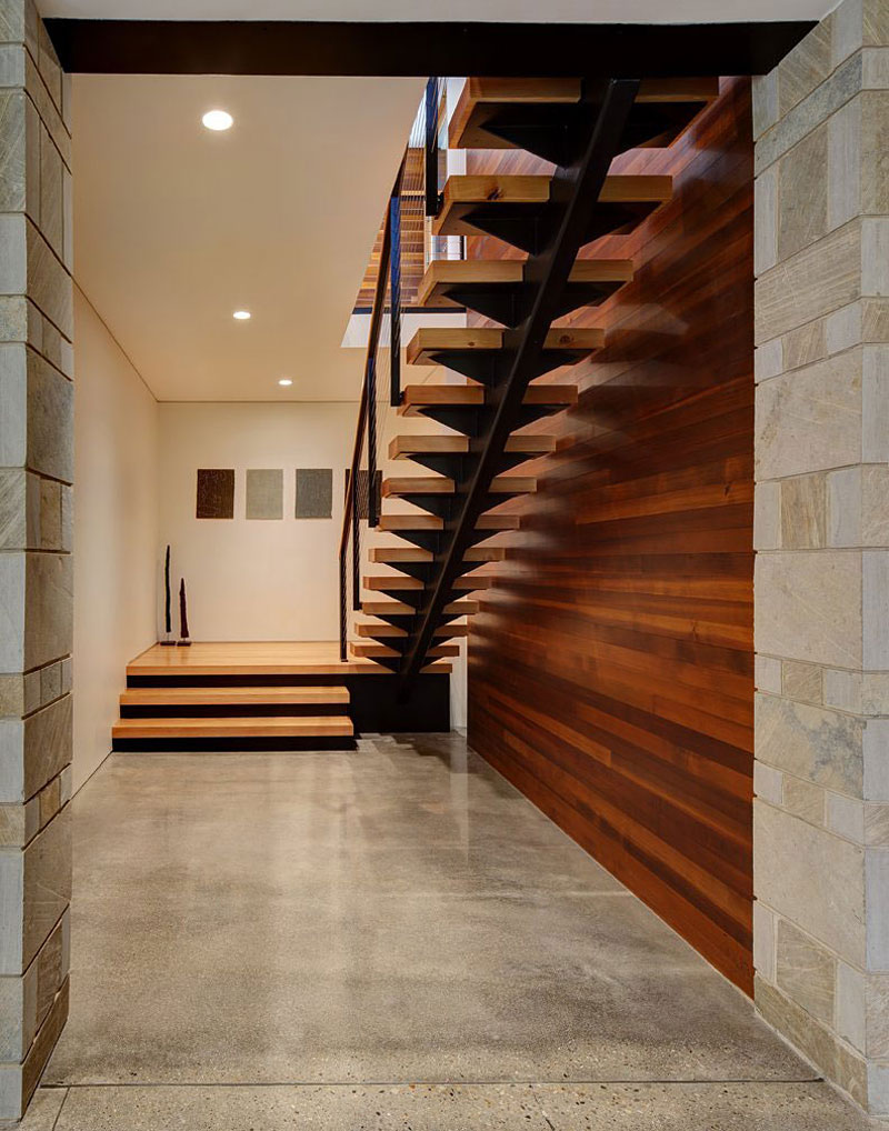 Fieldstone House Minimalist and contemporary home with wooden wall and stair